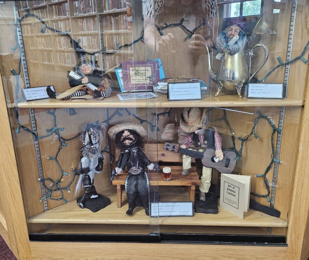 A photo of the display case filled with handmade figures made by Sandy Dale