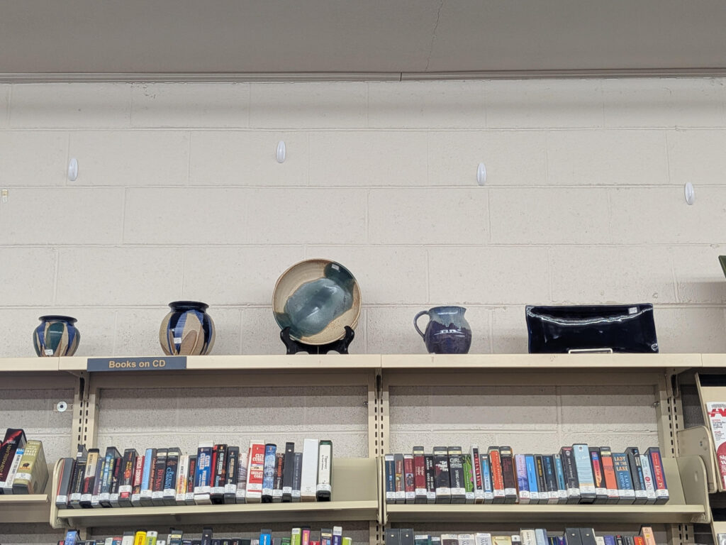 A collection of pottery pieces on top of one of the shelves