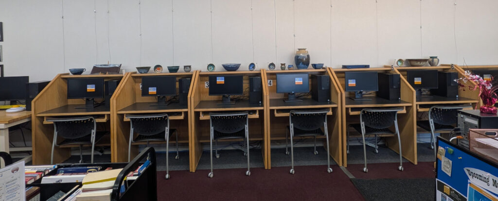 Computer desks topped with pottery pieces